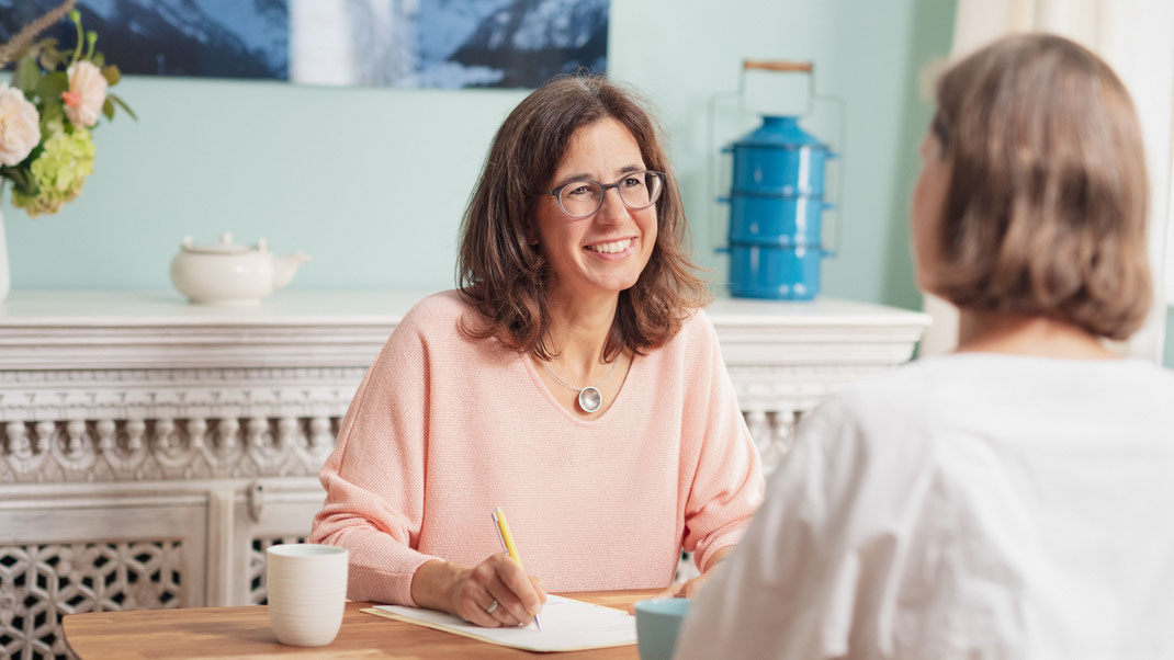 Heilpraktikerin stephanie leßmann während einer ernährungsberatung mit einer patientin am tisch sitzend in praxis in weimar